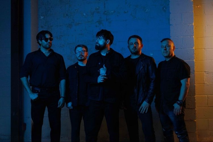 The five members of Absent Theory against a lit concrete wall
